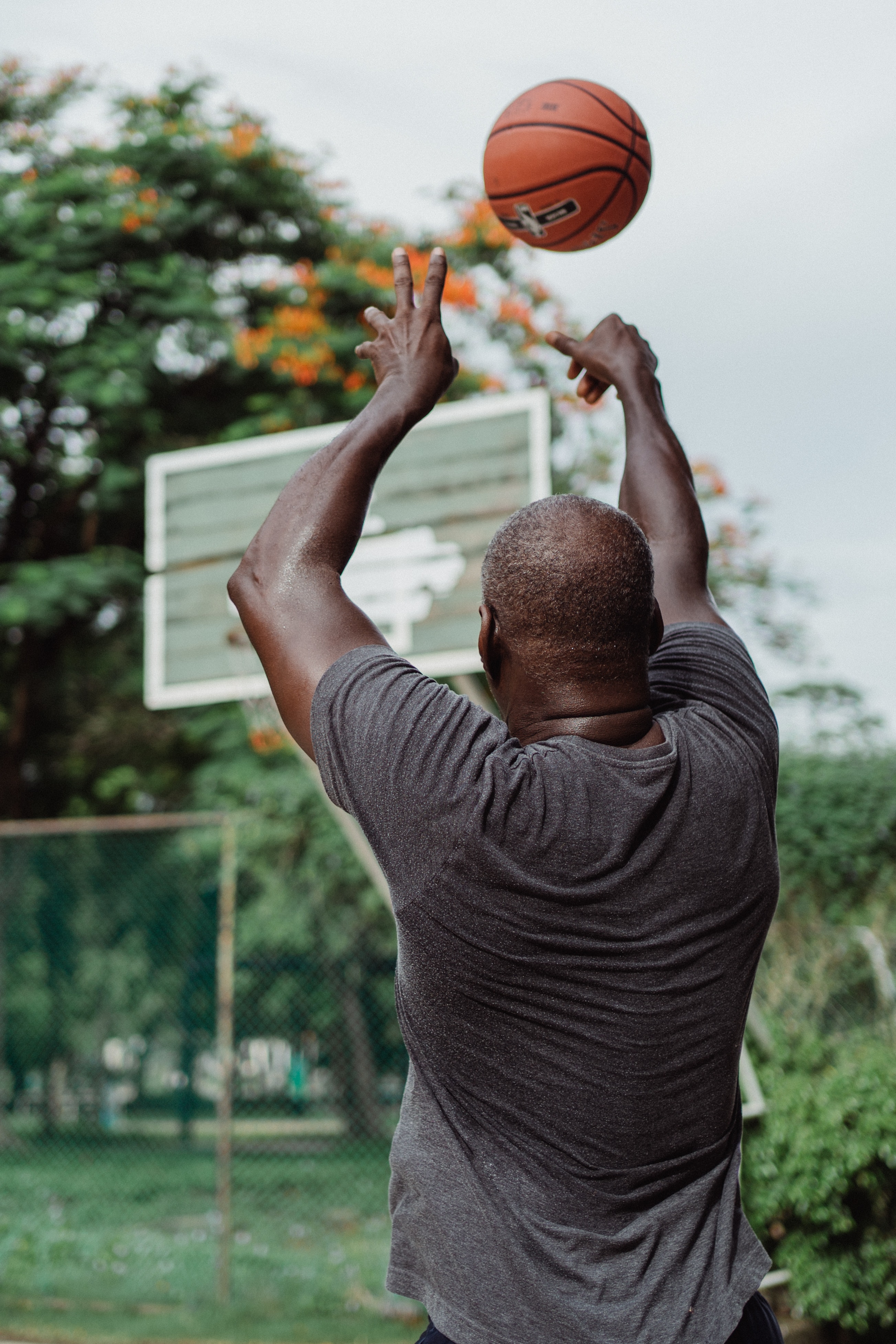 black man shooting basketball from behind