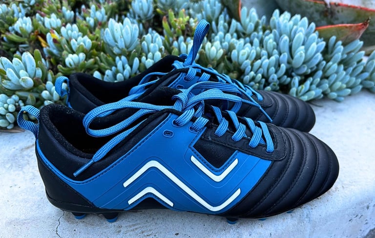 IDA sports soccer cleats. Black cleats with blue and white zigzag pattern.