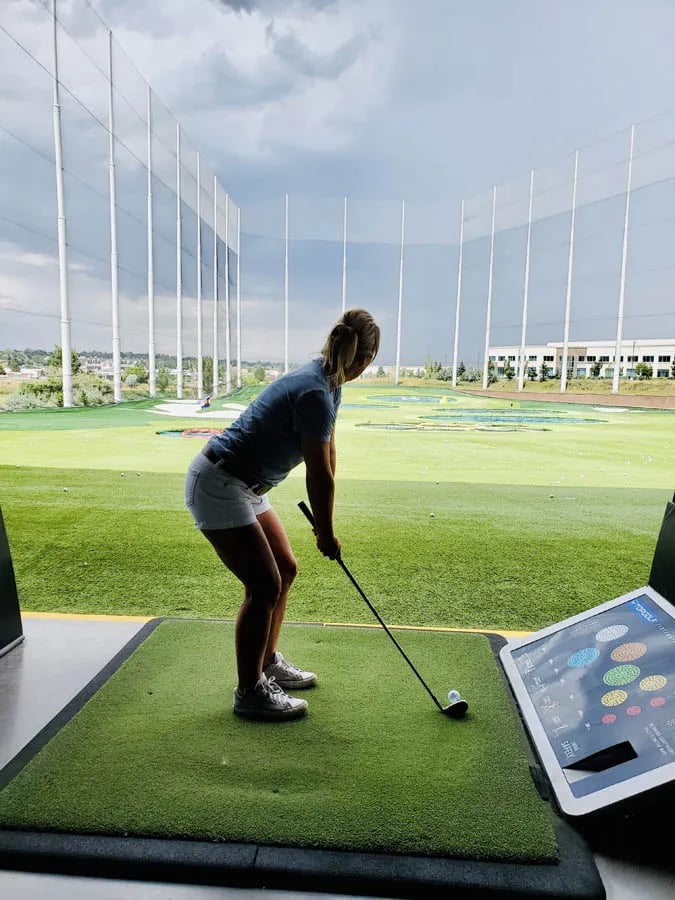 woman at top golf getting ready to tee off