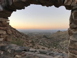 Phoenix desert with rocky arc in foreground and sunset in background