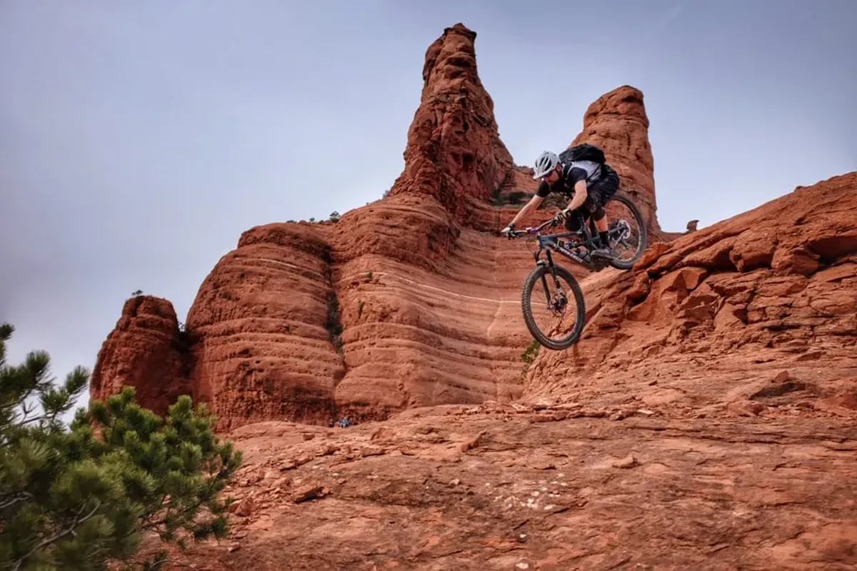 guy on mountain bike riding down canyon rock