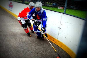 opposing roller hockey players going after ball