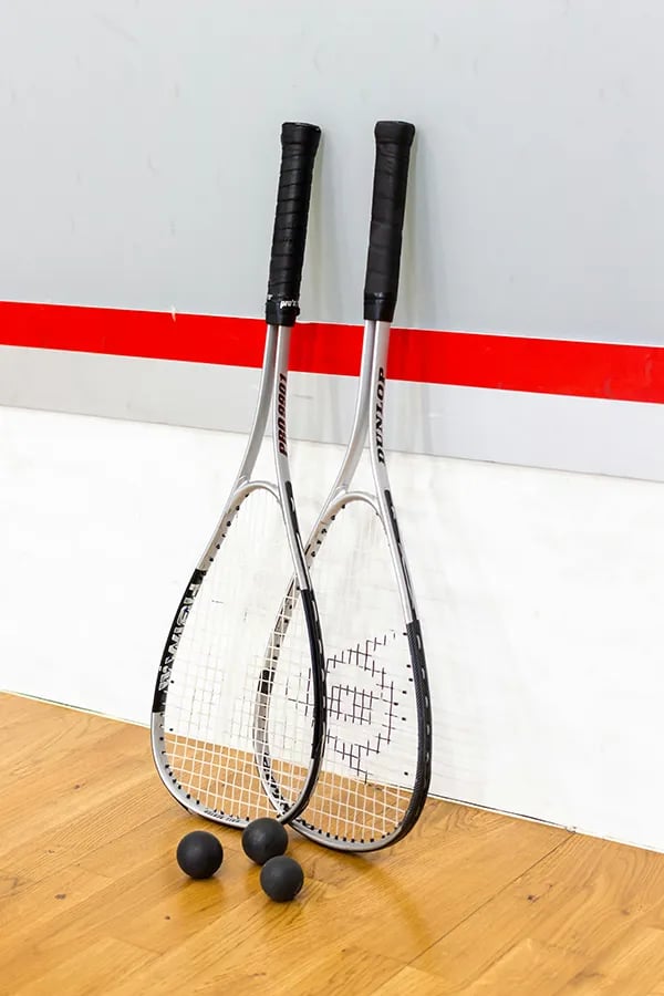 pair of squash racquets against the wall
