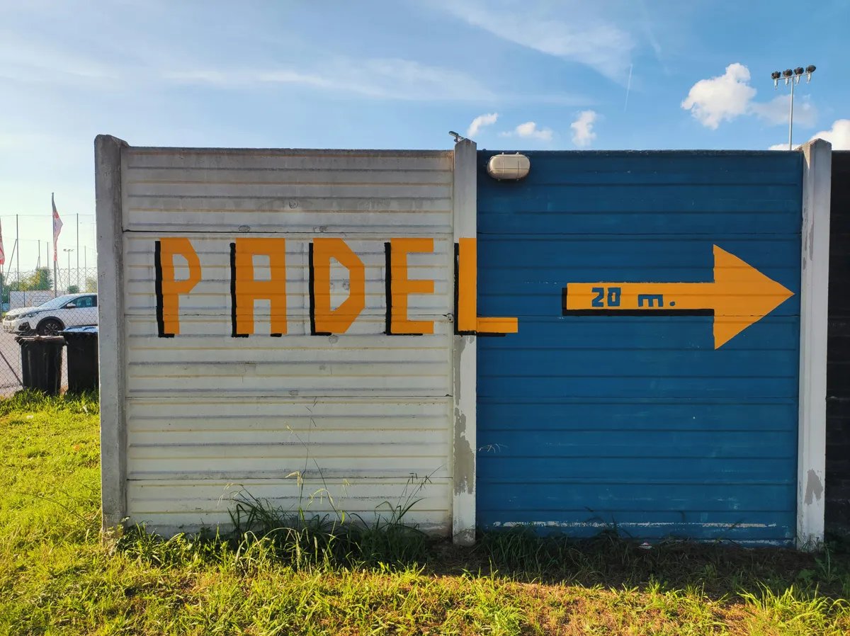 wall with "padel" and an arrow painted on it pointing right