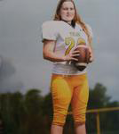 Female football kicker posing with ball
