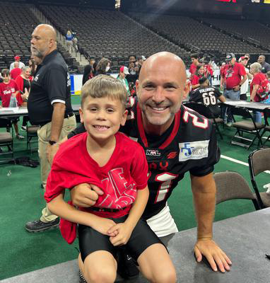 Mike Hollis with a young fan after football game
