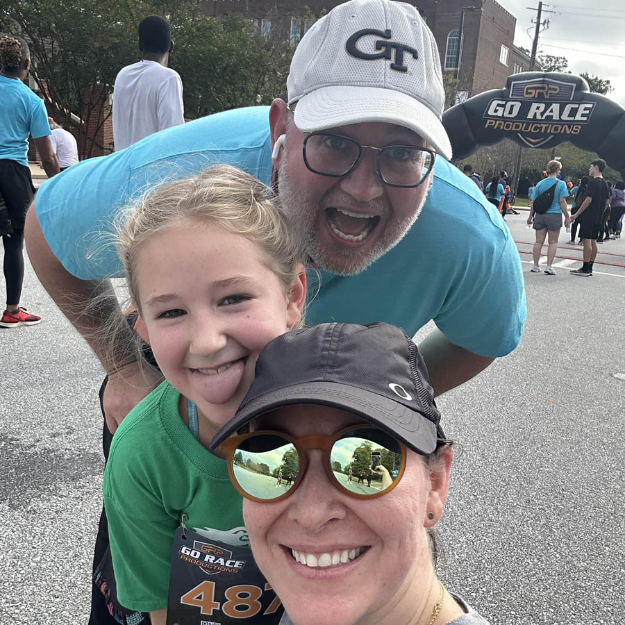 John Moore's family photo with wife and 8-year old daughter at a 5k race taking a selfie together