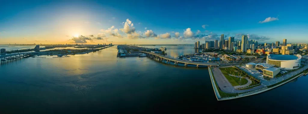 panoramic view of miami skyline with cityscape, stadium, ocean, and bridges
