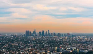 cityscape of downtown los angeles and outlying areas with orange clouds in sky