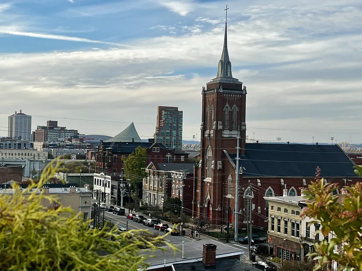 arial view of louisville street with red church in foreground and stadium in background