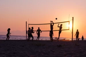 beach volleyball game with silhouettes at sunset