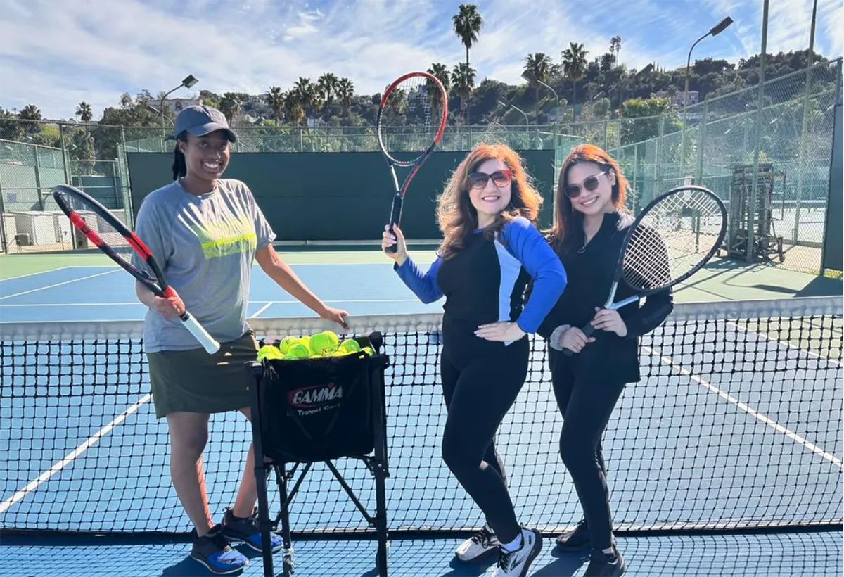 Three women tennis players posing on the court