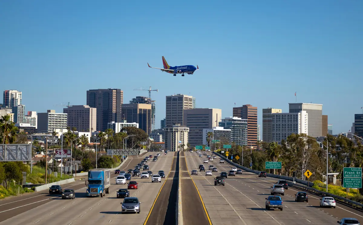 skyline of san diego with plane overhead