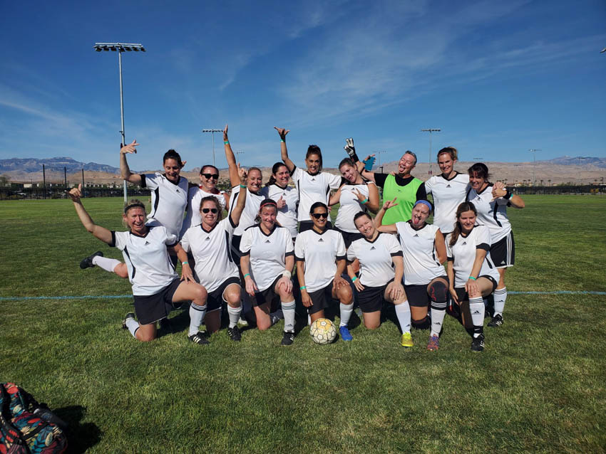 female soccer team poses goofily in group