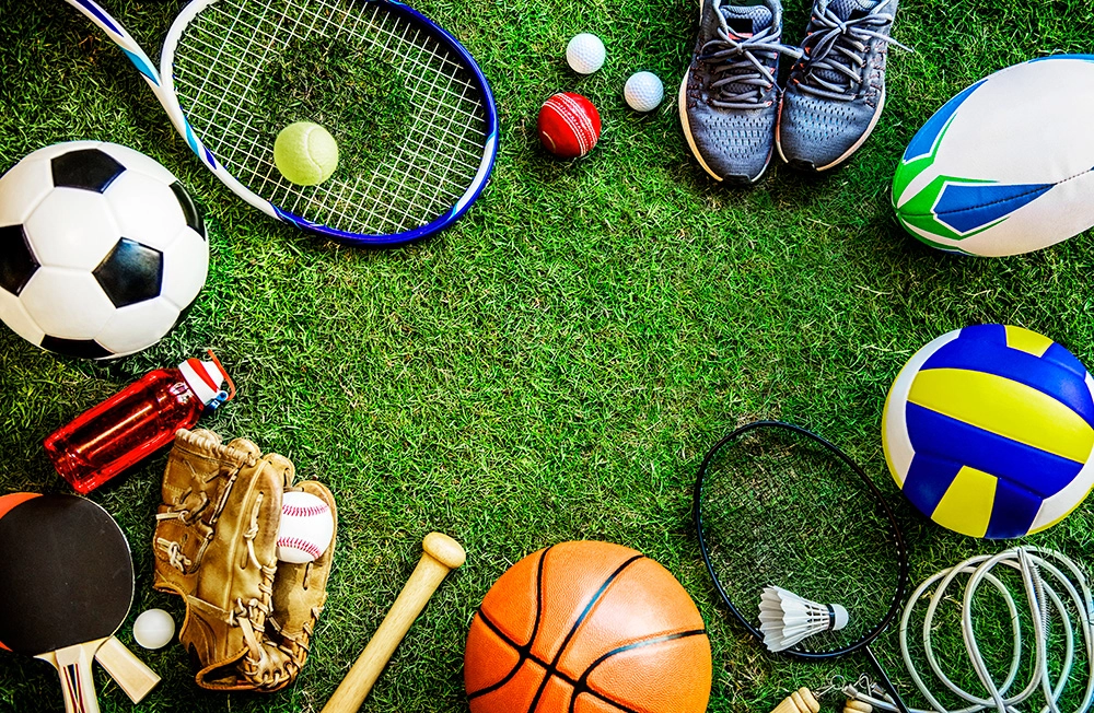 photo of different sports gear in a circle on grass to emphasize reasons to play sports