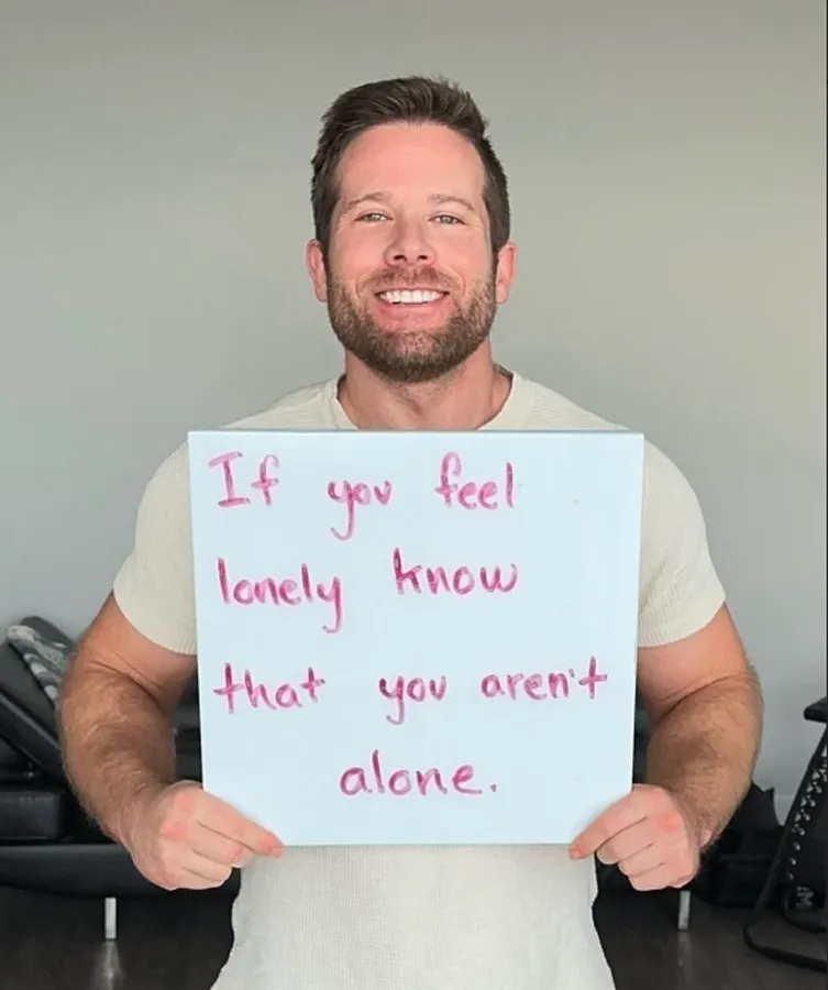 alex wisch holding sign about mental health
