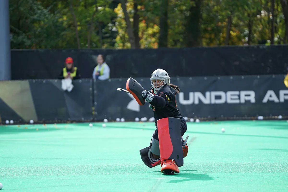 female lacrosse goale on her knees