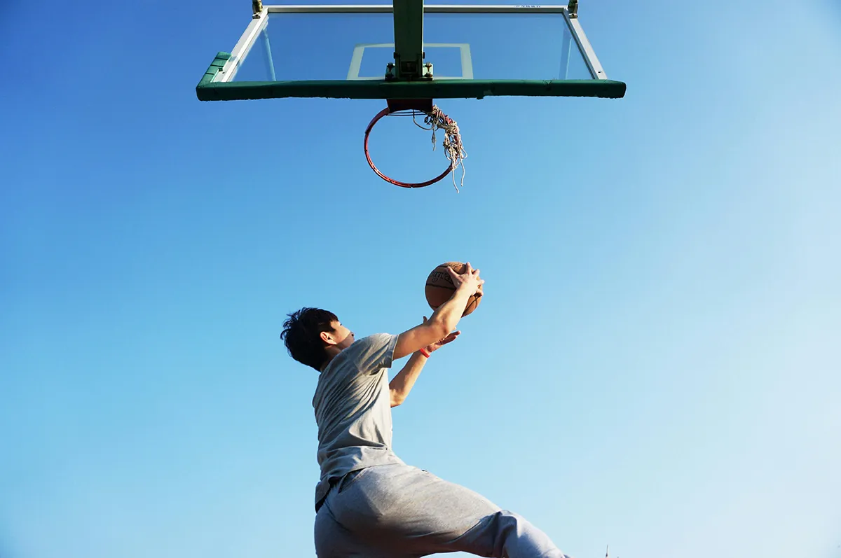 adult basketball player jumping toward hoop