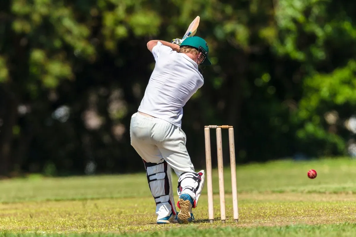 man hitting cricket ball