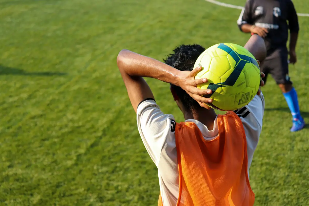 man taking a throw in in soccer shot from behind