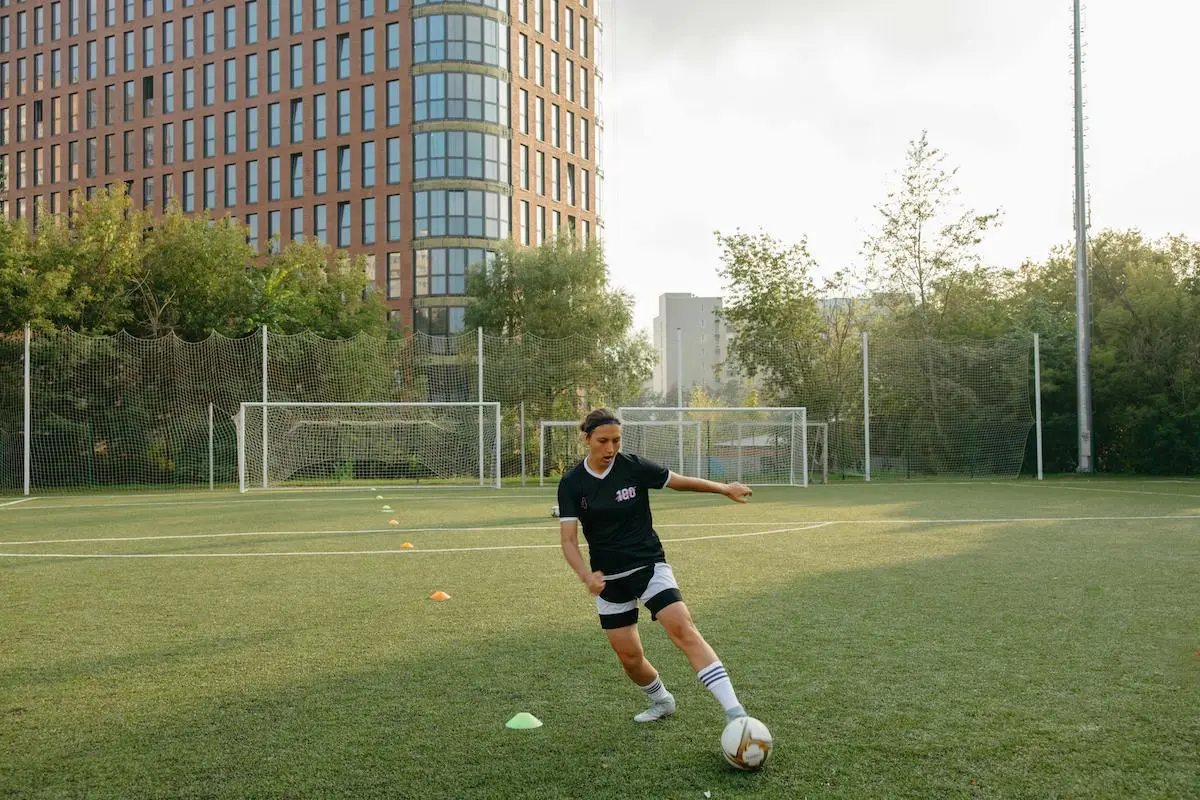 woman soccer training with cones on field