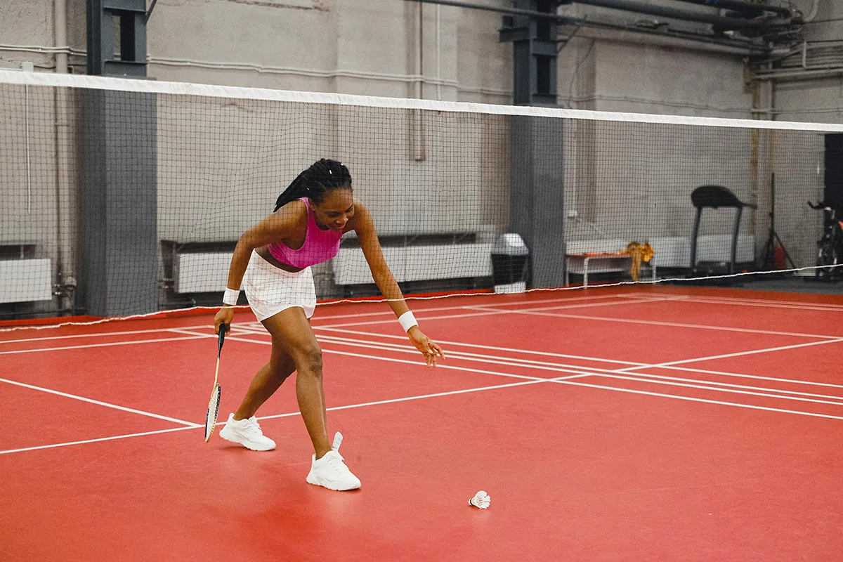 woman on badminton court holding racqut