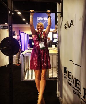 woman in purple dress hanging from pullup bar